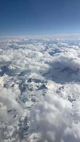 Aerial view of clouds over snowy mountains
