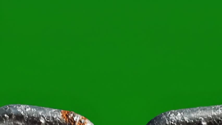 A detailed close up shot of a rusty metal chain with interlocking links against a solid green background.