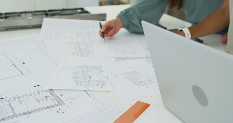 Female team working on design after opening laptop, reviewing blueprints on studio table, pointing. Architect, business, modern, architecture, workspace, collaboration, plans