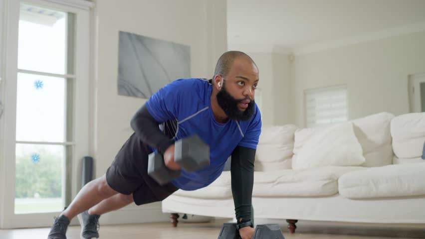 Man holding plank and starting dumbbell rows, blue node net appearing and tracking fitness metrics. Home, sofa, strength, training, routine, focus, biometric