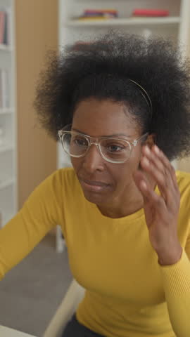 Woman typing on computer with hands on keyboard then cheering with raised fists in a building; joy success celebration.