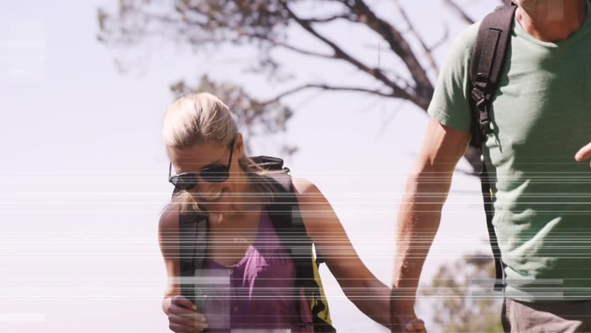 Couple holding hands walking for travel cam tilting as glitch lines passing revealing smiles, packs. Duo, hiking, outdoors, backpacks, sunglasses, canopy, sunlit