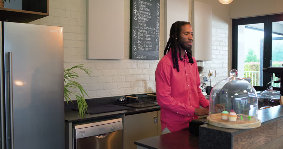 African American barista noticing guest, adjusting register, serving customer at cafe, copy space. Counter, beverage, hospitality, modern, urban, friendly, professional