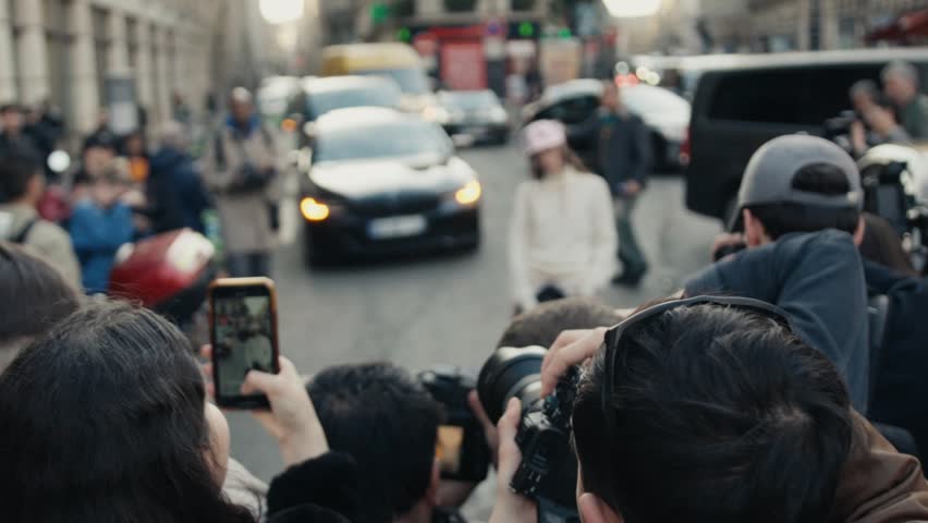 Photographers and fans filming celebrity on the street
