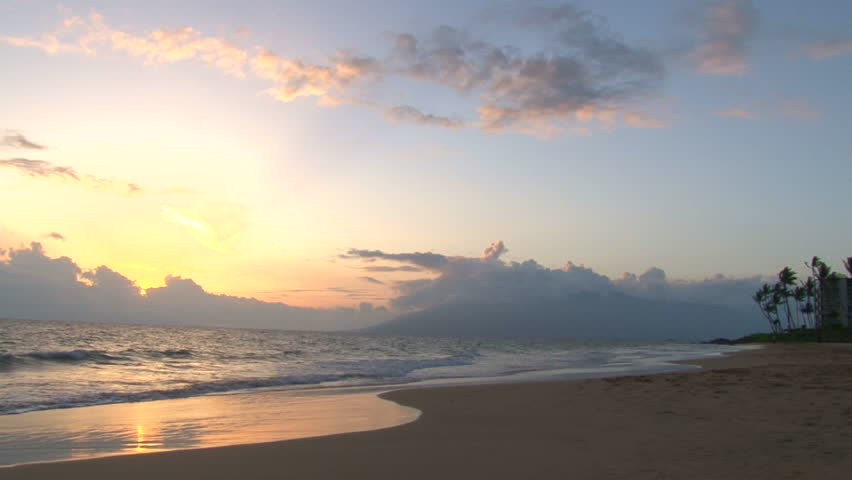Sunset over Pacific Ocean in Hawaii on sandy beach, time lapse.