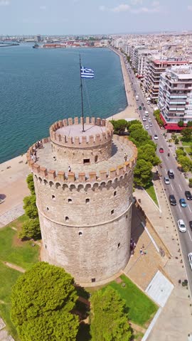Aerial view of the iconic White Tower standing by the Thermaic Gulf with the city and mountains behind in Thessaloniki, Greece