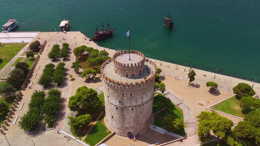 Aerial view of the White Tower landmark on the waterfront with pirate tour boats in Thessaloniki, Greece