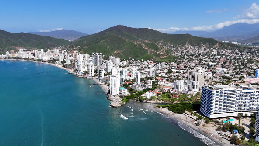 Drone footage of Gaira, Santa Marta, Colombia, featuring aerial views of the Caribbean coastline, surrounding cityscape, and nearby mountains.