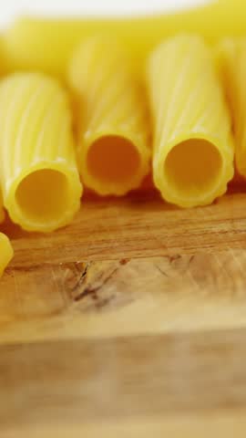 Close-up of penne and conchiglie pasta on chopping board
