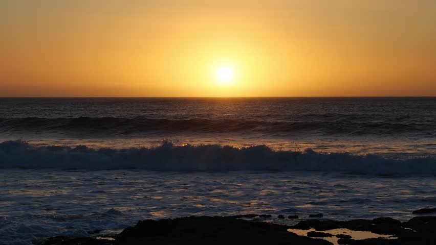 Red Sun Setting Over Calm Sea Horizon at Sunset. Golden Evening Sky and Red Sun Above Tranquil Sea. Romantic Tropical Sunset with Sun Descending into Ocean. Scenic Seascape with Bright Red Sun at Dusk