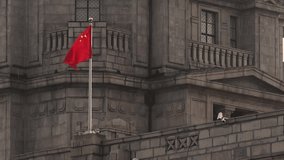 Chinese flag waving on wind against gray stone building facade - Powered by Shutterstock - Get 15% off with code: PIKWIZARD15