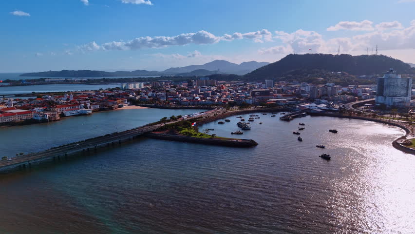 Approaching the harbor with boats standing on the anchor. Panama flag is on the dam. Panama City, Republic of Panama, North America.