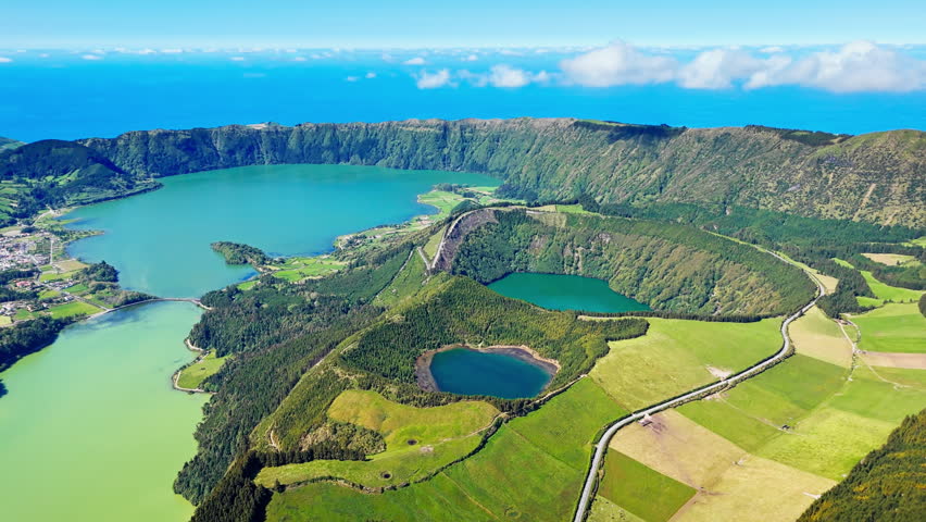 Volcanic caldera containing twin lakes and coastal backdrop on Sao Miguel Island, Azores, drone view