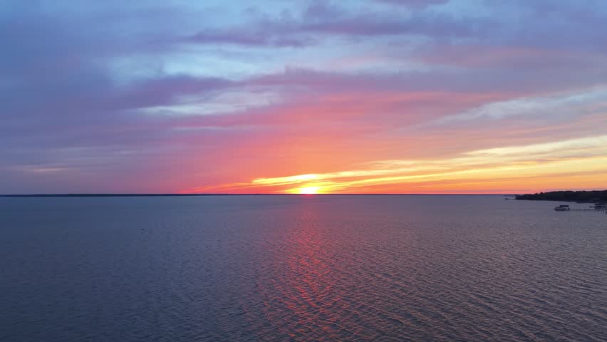 James River coastline in Newport News, Virginia, aerial sunset video, featuring luxury waterfront residential homes and a vibrant evening sky. 