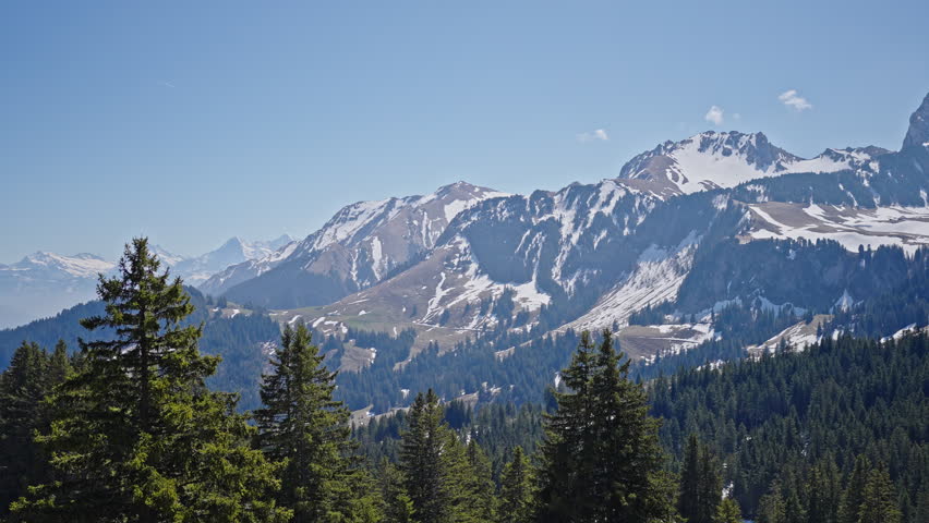 Alpine mountain scenery with forest and snow peaks Switzerland 4K