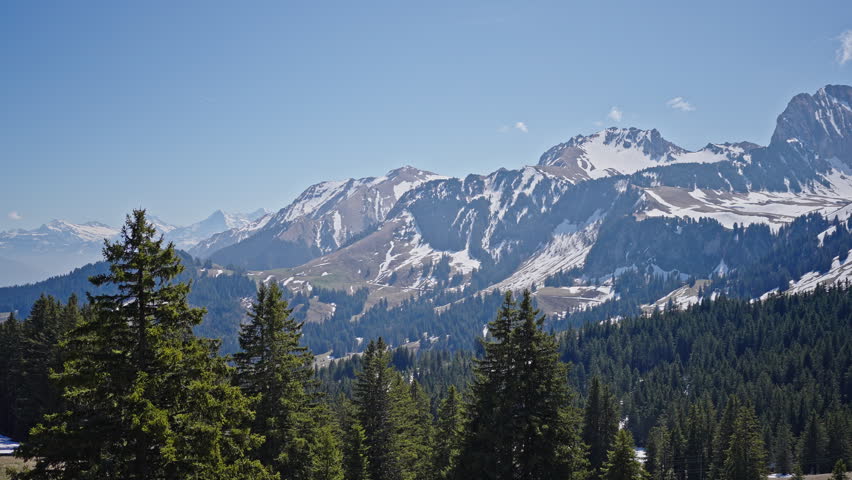 Swiss Alps panoramic mountain range with forest and snow peaks 4K