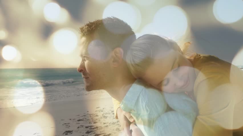 Man carrying woman on beach, bokeh shifting revealing faces, woman smiling for romance marketing. Couple, shoreline, sea, sunlit, warmth, embrace, dreamy
