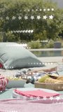 Vertical video: Star overlay drifting, starting slow pan right, revealing picnic spread and pool. Outdoor, backyard, vibrant, alfresco, platter, napkins, vertical video - Powered by Shutterstock - Get 15% off with code: PIKWIZARD15