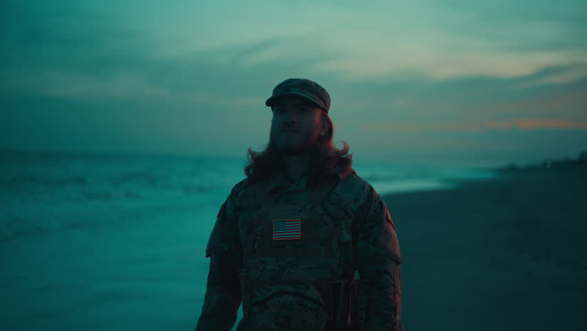 Silhouette of an American soldier saluting near the stormy ocean At Memorial Day