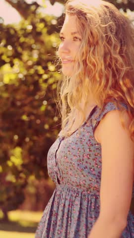 In high quality 4k format pretty blonde smiling in the park on a summers day