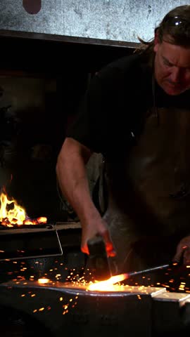 Blacksmith working on a iron rod in workshop 4k