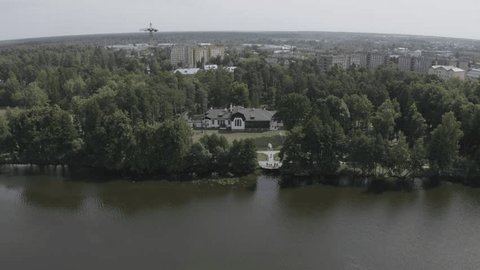Drone Descending toward Forest House by River