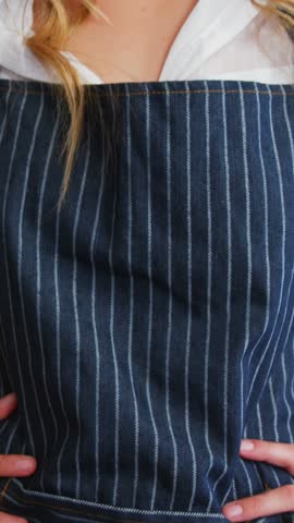 Portrait of waitress is smiling and posing with hands on hips at restaurant