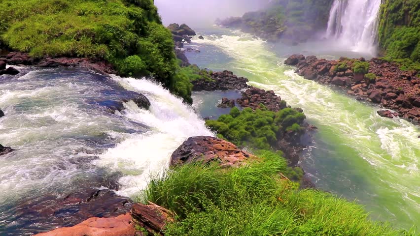 Foz do Iguacu Iguazu Falls waterfall fall waterfalls cascade cascades in tropical nature rainforest panorama view with turquoise green water and blue sky in Parana Brazil and Misiones Argentina.