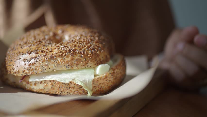 Bagel with cream cheese on wooden board