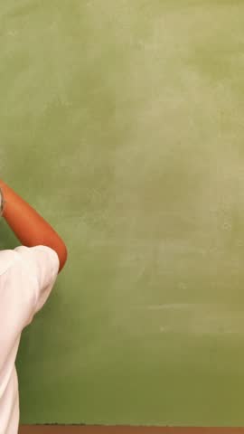 in classroomCute pupil writing maths on chalkboard at the elementary school