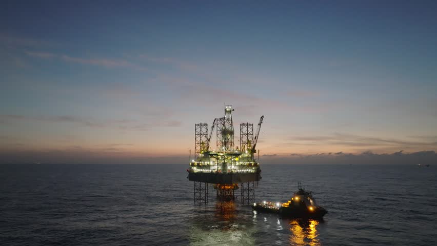 Aerial top view of offshore jack up rig and offshore platform during sunset for oil and gas exploration and production. 
