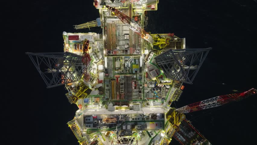Aerial top view of offshore jack up rig and offshore platform during sunset for oil and gas exploration and production. 
