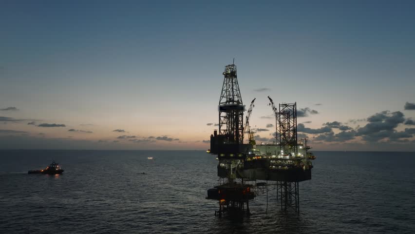 Aerial top view of offshore jack up rig and offshore platform during sunset for oil and gas exploration and production. 
