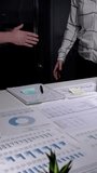 Business professionals shaking hands during an evening meeting, confirming a successful agreement and partnership while reviewing financial data, charts, and reports spread across a desk - Powered by Shutterstock - Get 15% off with code: PIKWIZARD15