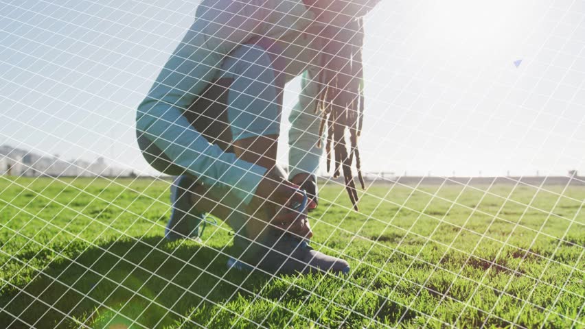 Adult woman crouching and adjusting laces in sunny field, bending motion calling blue tech graphics. Female, meadow, outdoor, backlit, lensflare, data, visualization