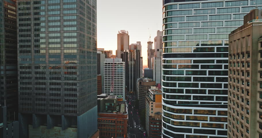 Modern cityscape drone flight. Sydney Central Business District modern skyscrapers and urban architecture at sunrise, with light reflecting on high building glass facades and city streets waking up