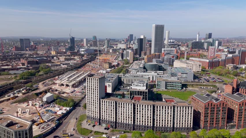 Aerial panoramic footage of a Birmingham cityscape skyline with apartment buildings and student accommodation next to new HS2 railway lines in the Curzon Street area of this vibrant West Midlands city in the UK