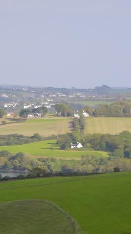 Panoramic shot of green fields and lake in the countryside