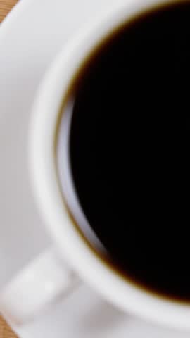 Close-up of coffee cup with saucer on wooden table 4k