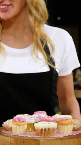 Portrait of smiling waitress standing with dessert in cafÃ© 4k