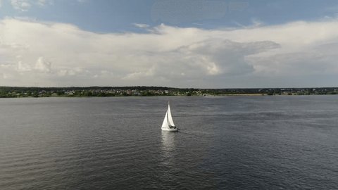 Drone Filming Sailboat Moving across Wide River