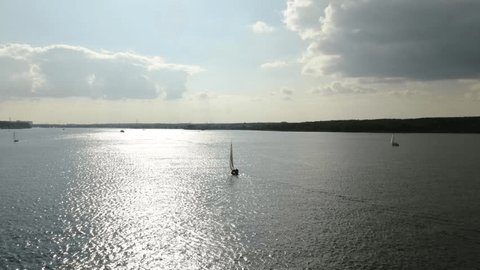 Aerial Tracking Shot Sailboat on Bright River