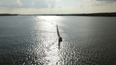 Drone Flying beside Sailboat on River