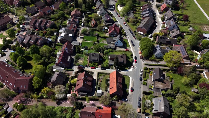 Aerial flyover small american village at sunny day. Empty quiet roads. Top down shot. Green trees at sunset in summer. Calm and peaceful city on United States. Spring season.