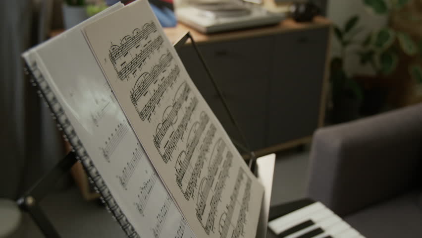 Close up detail shot of music notes on stand in studio apartment, ready for music lesson or practice, no people, copy space Useful for educational content about learning music theory