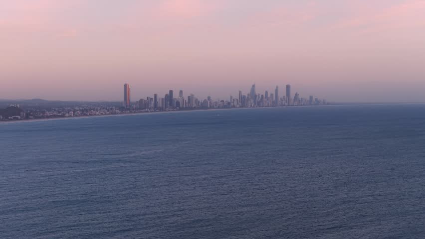 Surfers Paradise Skyline In Gold Coast, QLD, Australia - Towering Buildings Against Sunset Sky With Pacific Ocean In Foreground. wide drone shot