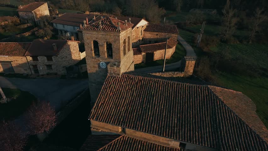 Aerial view of a historic stone building in a rural landscape at sunset.
