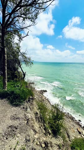 Scenic Coastal View with Lush Greenery and Turquoise Waters Under Clear Blue Sky