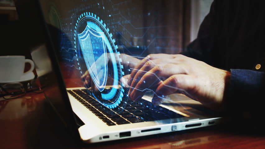 Cyber security shield symbol and man typing computer keyboard. Hands on laptop. Network, cyber technology and background abstract concept.