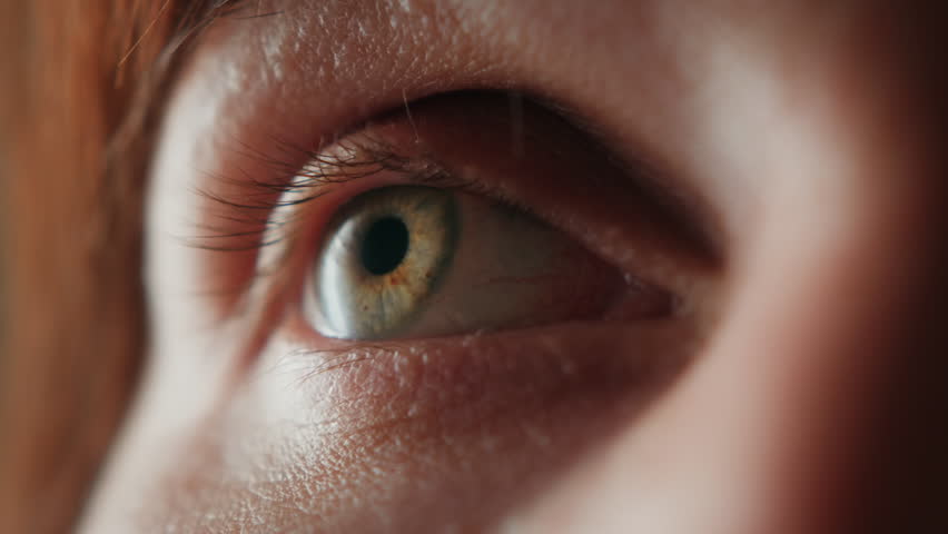 A close-up of the human eye in natural light. A detailed macro shot showing the eyelashes, iris, and skin texture. An emotive gaze conveying introspection, focus, or sensitivity. High quality 4k